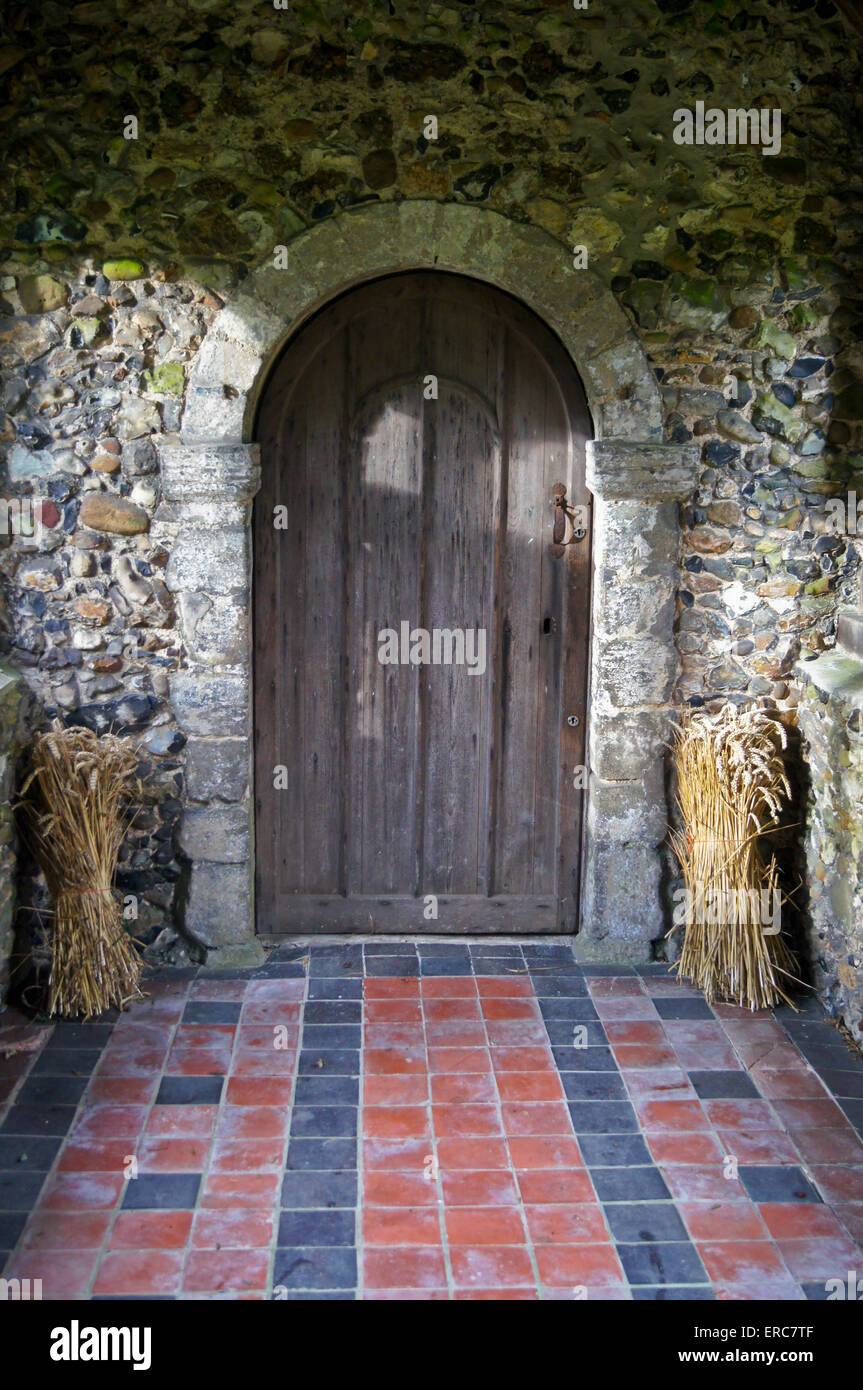 Portico di San Michele e Tutti gli Angeli Chiesa, Roding plumbeo Essex, Inghilterra, con harvest festival offerte, covoni di grano Foto Stock