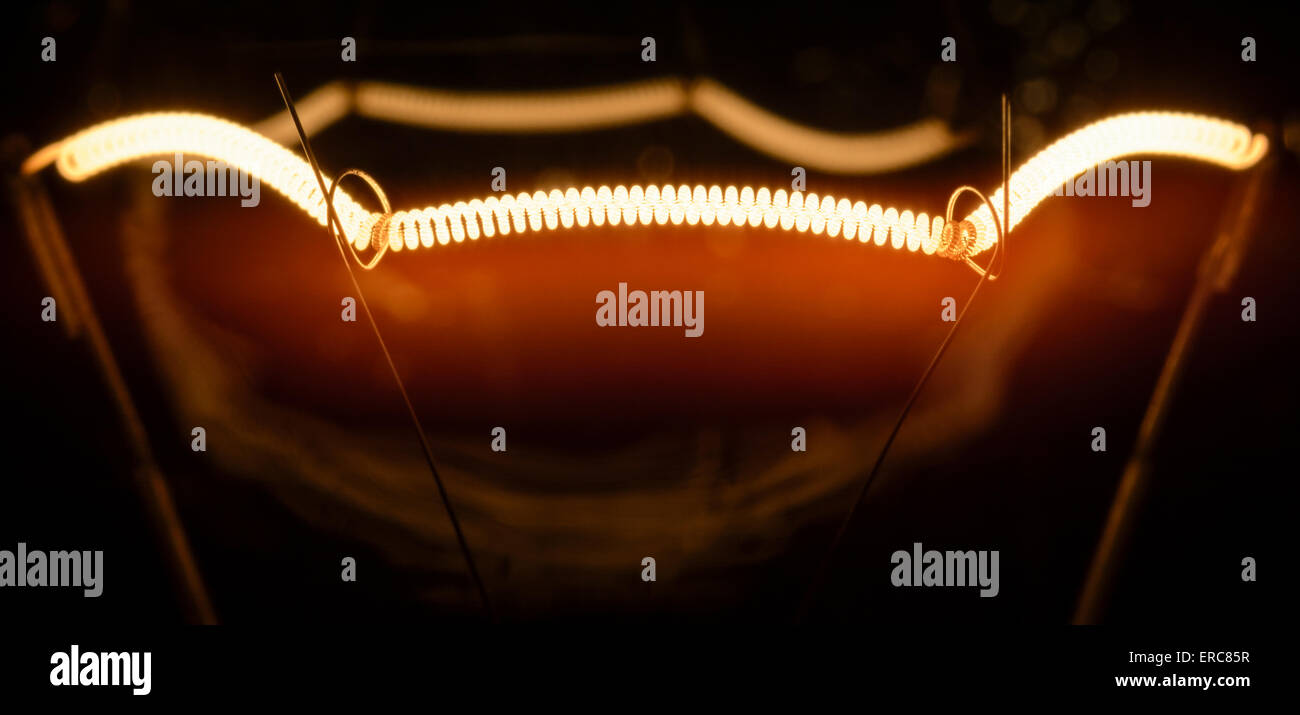 Il filamento di una lampada ad incandescenza lampadina elettrica, che sia acceso. Foto Stock