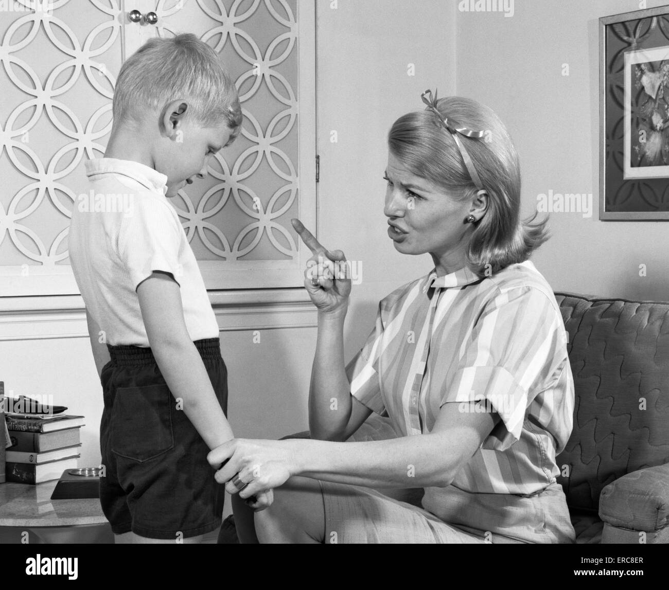 Anni Settanta disciplinando la madre di suo figlio parlando duramente e scuotendo il suo dito BOY appendere il capo per la vergogna Foto Stock