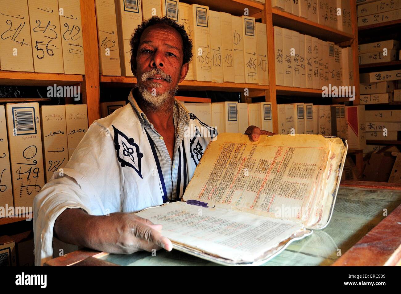 Lo studioso, uomo vecchio con un prezioso libro una libreria islamica nel centro storico, Chinguetti, Regione di Adrar, Mauritania Foto Stock
