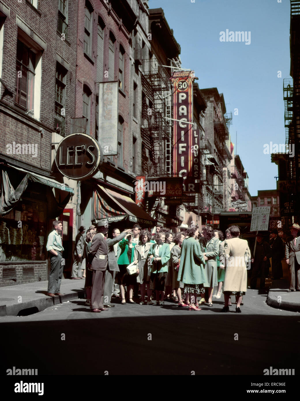 Negli anni quaranta I TURISTI IN GIRO PER CHINATOWN ANGOLO DI PELL E MOTT STRADE CON TOUR GUIDA indicando la via Foto Stock