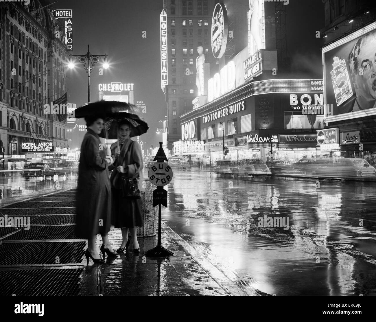 Anni Cinquanta due stagliano donne presso la fermata sotto gli ombrelloni notte piovosa TIMES SQUARE MANHATTAN NEW YORK STATI UNITI D'AMERICA Foto Stock