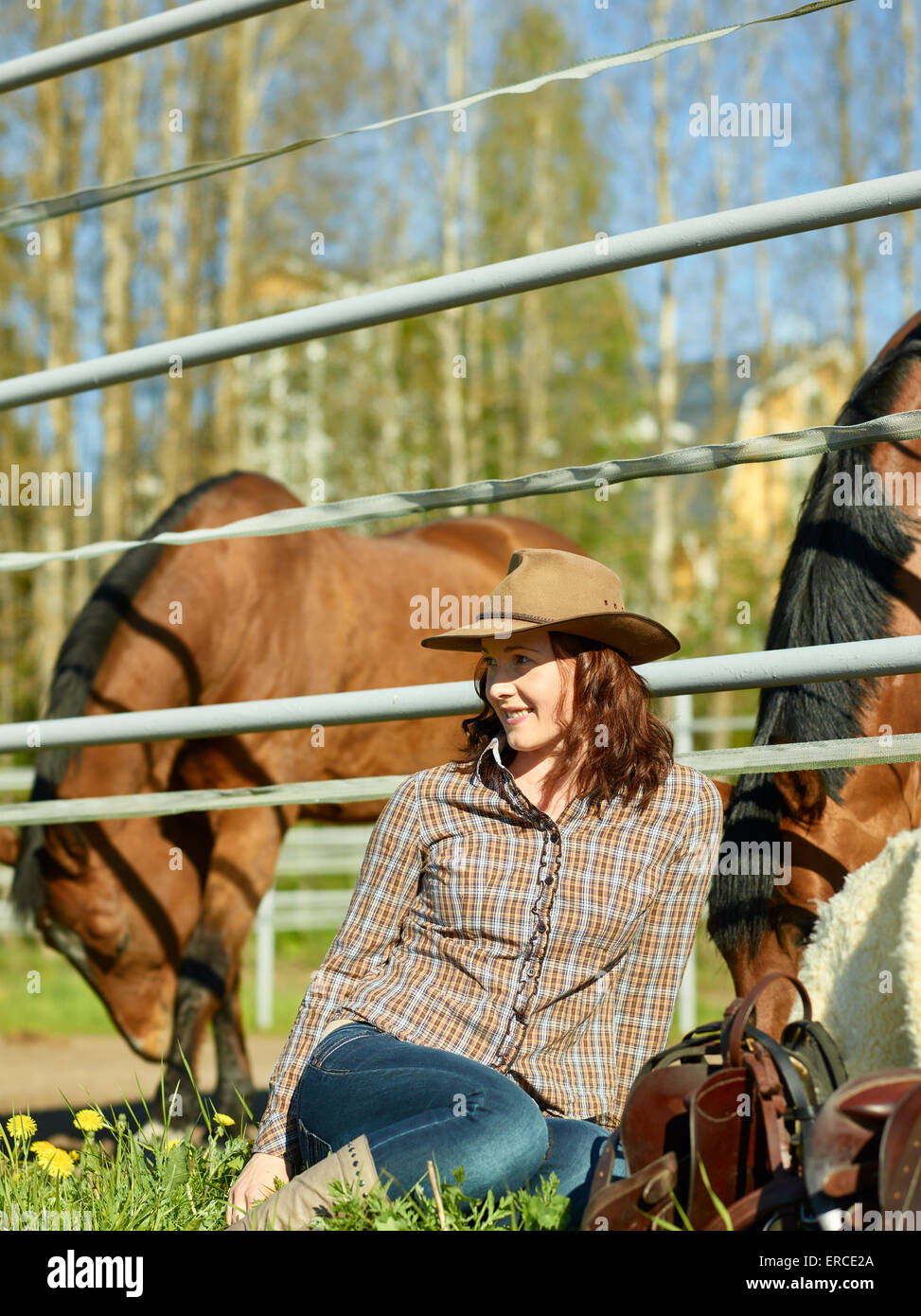 Cowgirl e sella di cavallo in un paddock Foto Stock