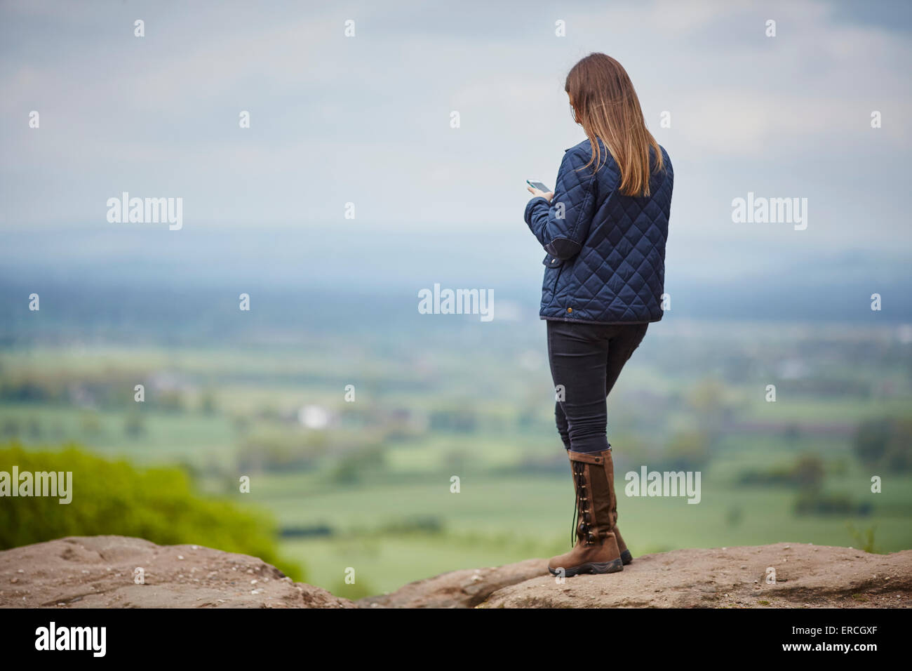 Giovani coupe sul bordo di pietra arenaria, vista dal punto di tempesta oltre al Pennines alberi il bordo a Alderley è una cresta di terra separa Foto Stock