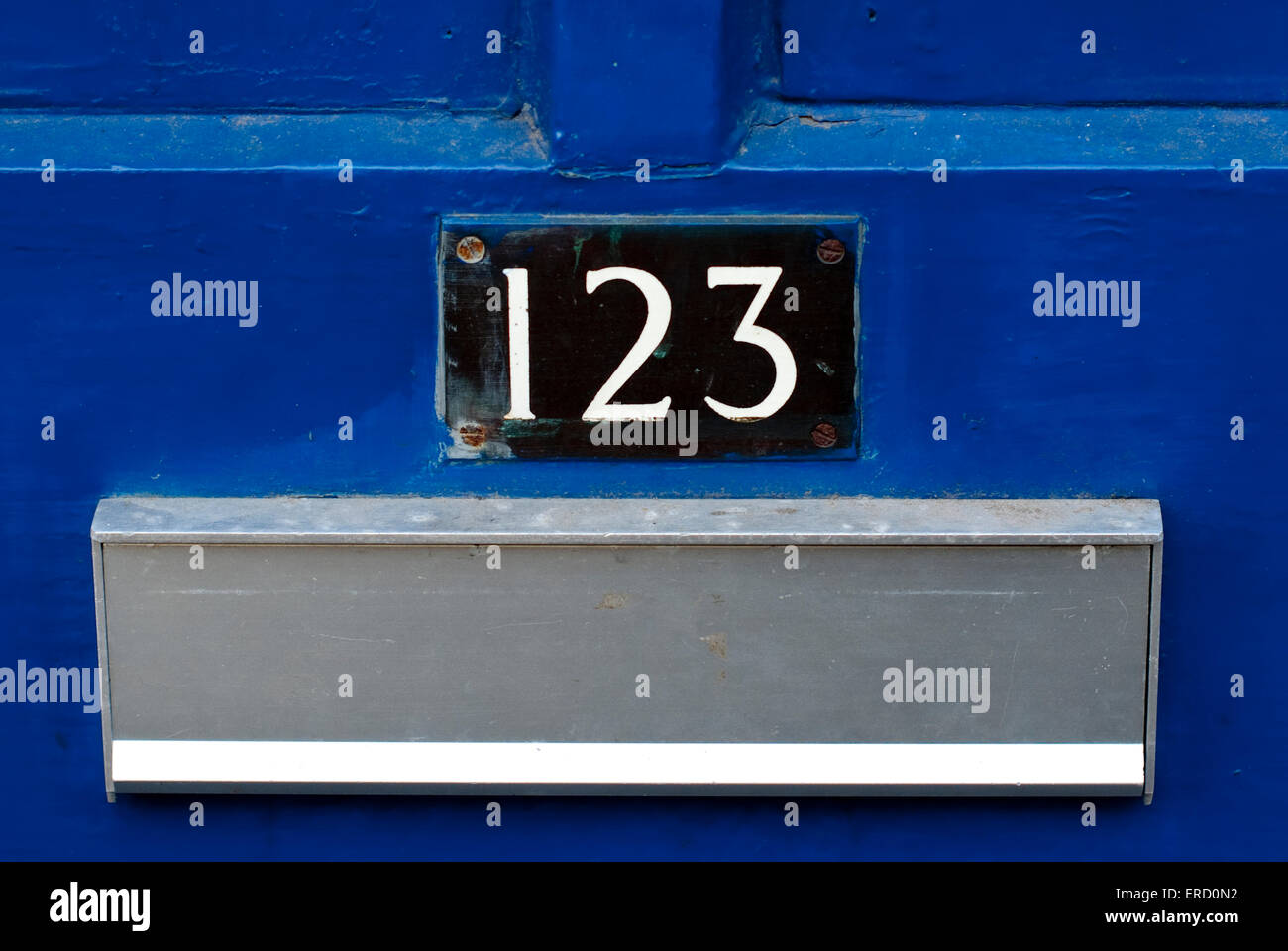 Documentario chiudere l immagine del numero civico 123 su un blu brillante porta con il letterbox in metallo in vista Foto Stock