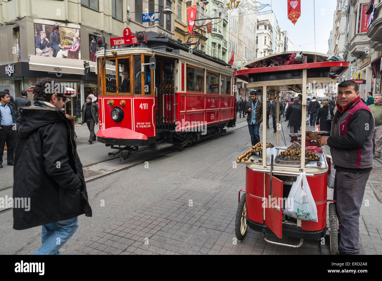 Tram e fornitore di castagno in Istiklal Caddesi, uno di Istanbul le principali zone di shopping center. Beyoglu, Istanbul, Turchia Foto Stock