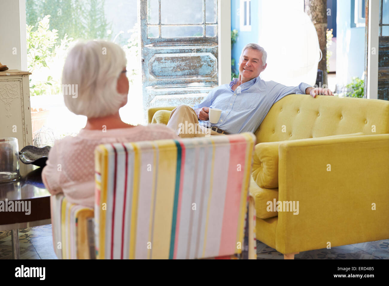 Coppia senior a casa rilassarsi nella Lounge con bevanda calda Foto Stock