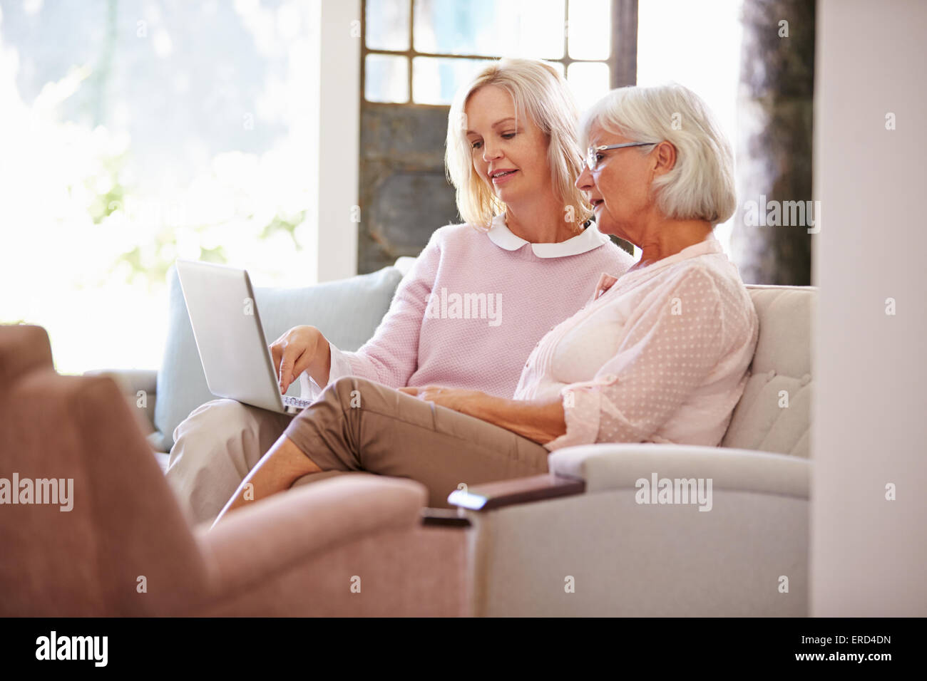 Figlia adulta aiutando Senior Madre con il computer di casa Foto Stock