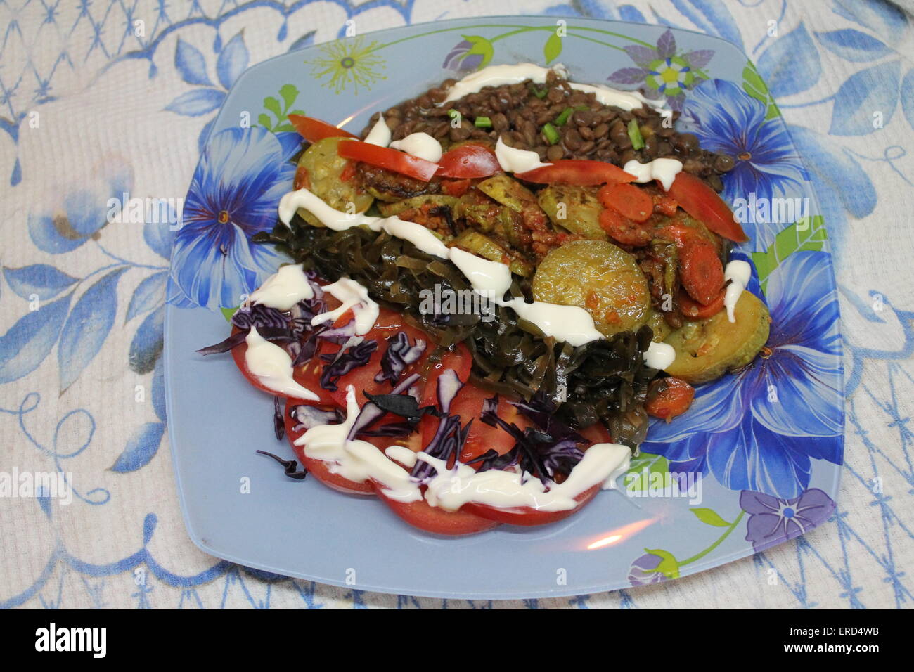 Sana appetitoso piatto vegetariano fette di zucchine, pomodori, alga, carota, bollire rosso semi di lenticchie Foto Stock