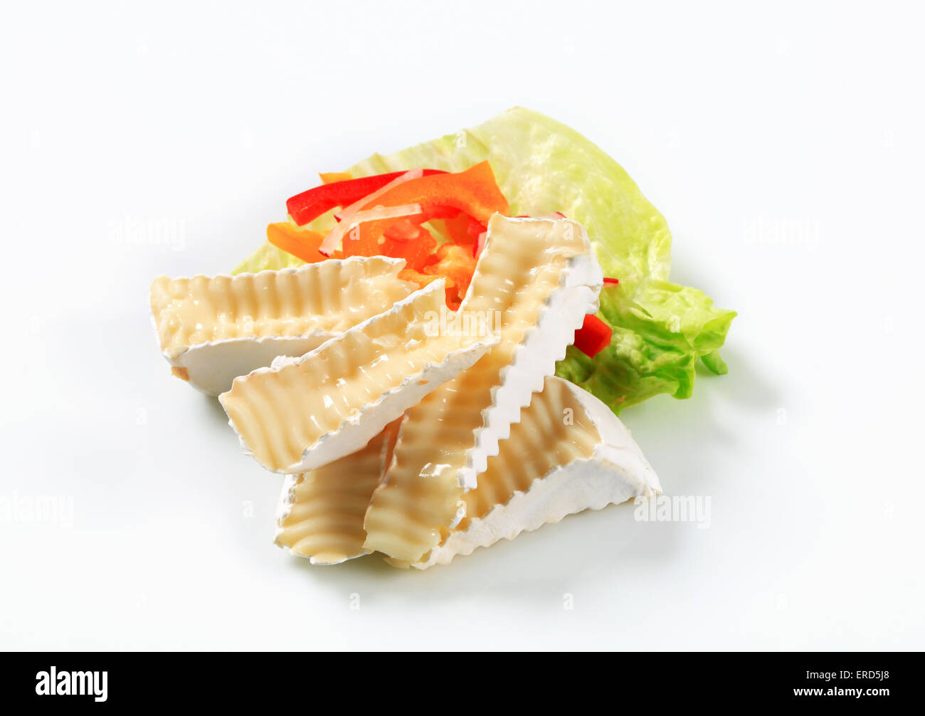 Cunei di bianco la crosta del formaggio e guarnire vegetale Foto Stock