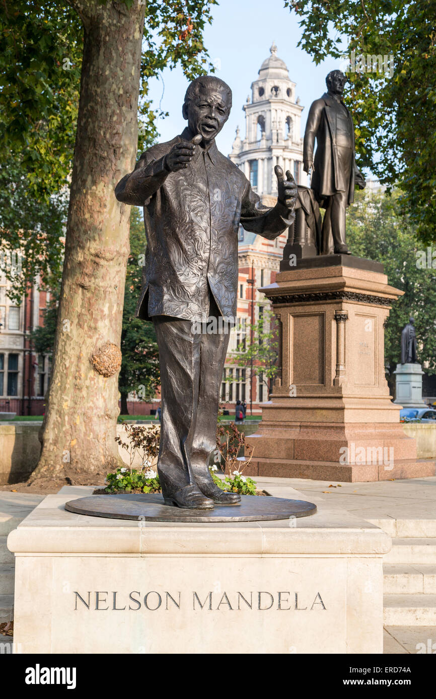 Regno Unito, Inghilterra, Londra. Nelson Mandela statua, la piazza del Parlamento. Sir Robert Peel in background. Foto Stock