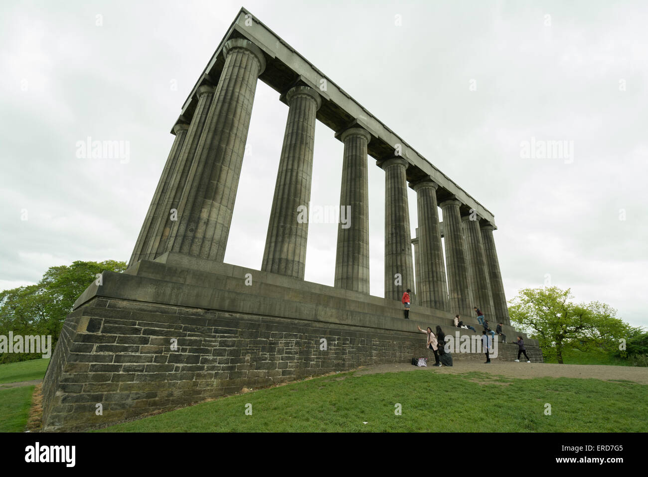Monumento Nazionale di Scozia - i turisti aggiungi un tocco di colore al grigio di una giornata scozzese sulla cima di Calton Hill, Edimburgo Foto Stock