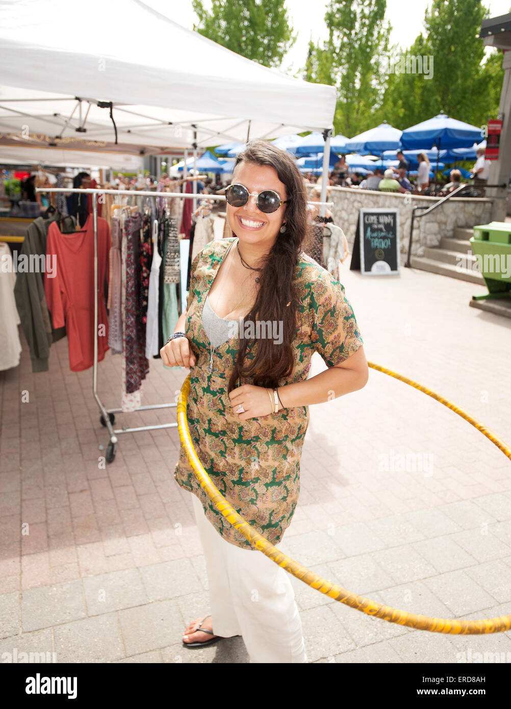 Jasmine Jade gira un hula hoop durante il lavoro presso il re: creazione stand al Whistler mercato agricolo. Whistler BC, Canada. Foto Stock