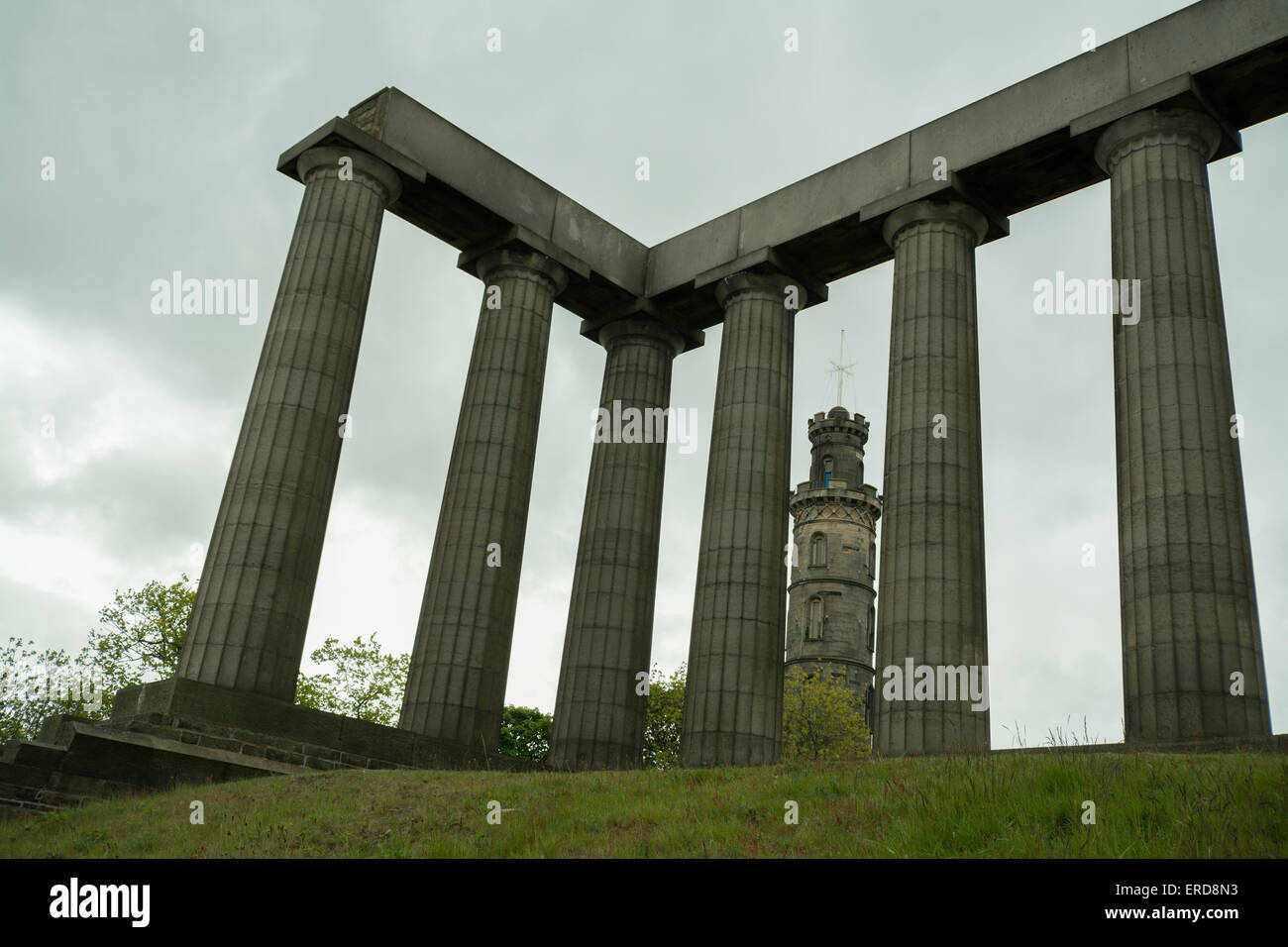 Monumento Nelson visto attraverso le colonne della incompiuta Monumento Nazionale di Scozia su Calton Hill - Edimburgo, Scozia Foto Stock