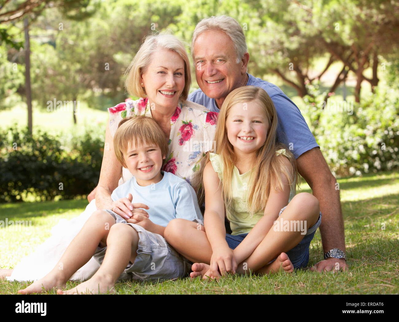 Nonni e nipoti in seduta Park insieme Foto Stock