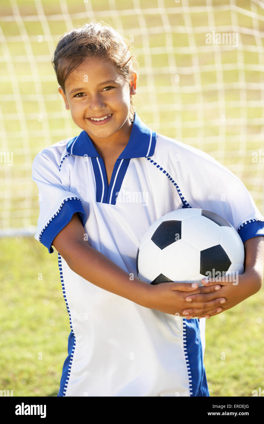 Giovane ragazza vestita in Kit calcio in piedi da obiettivo Foto Stock