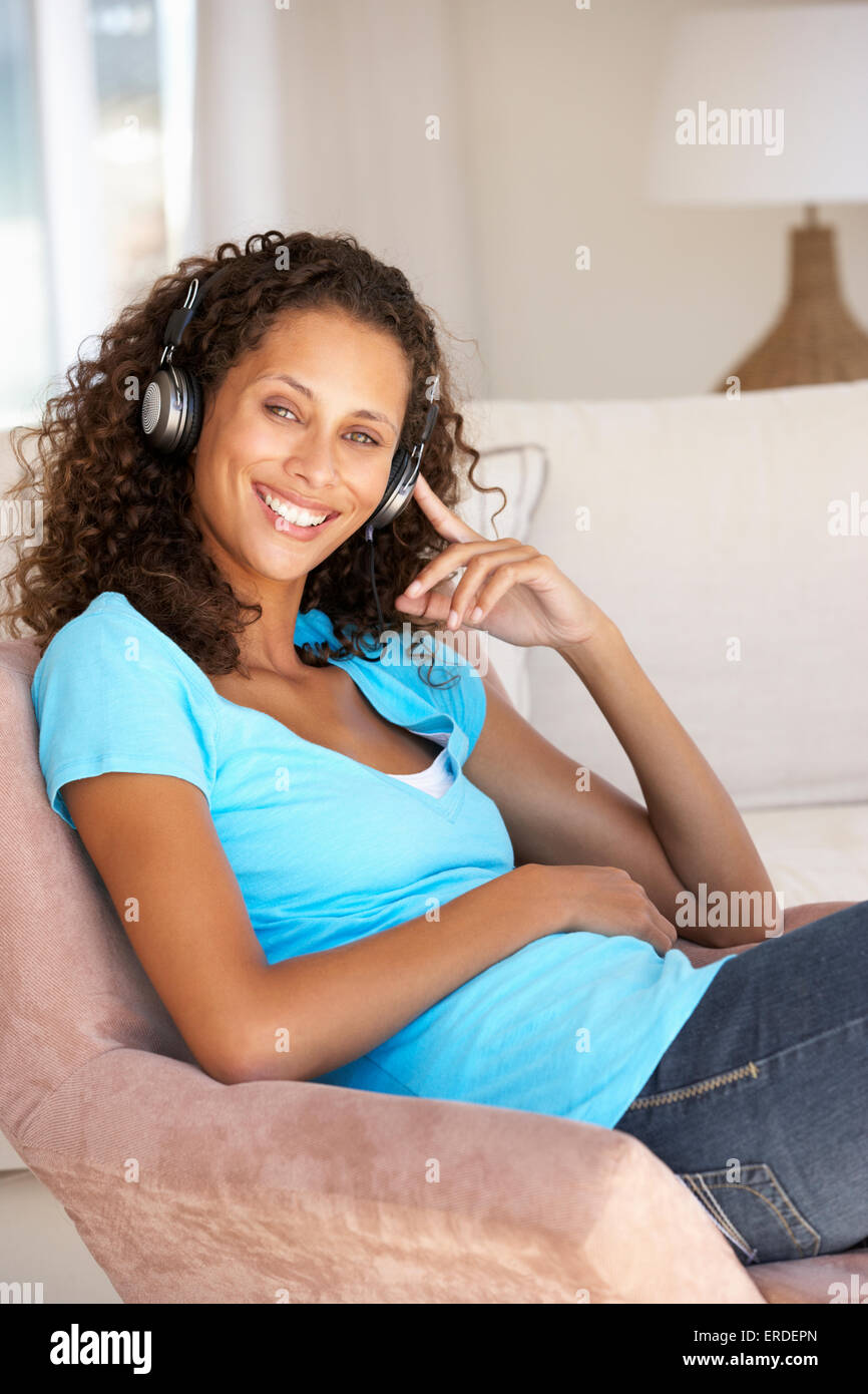 Giovane donna rilassarsi ascoltando la musica a casa Foto Stock