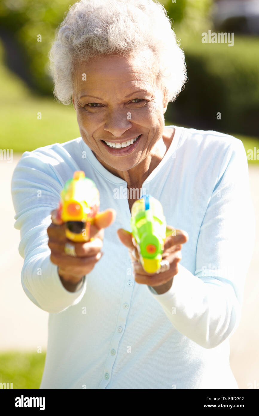 Senior riprese donna pistole ad acqua Foto Stock