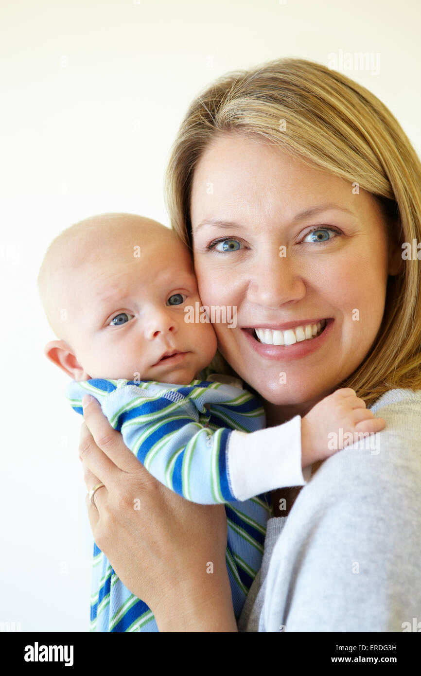 Madre cuddling baby Foto Stock