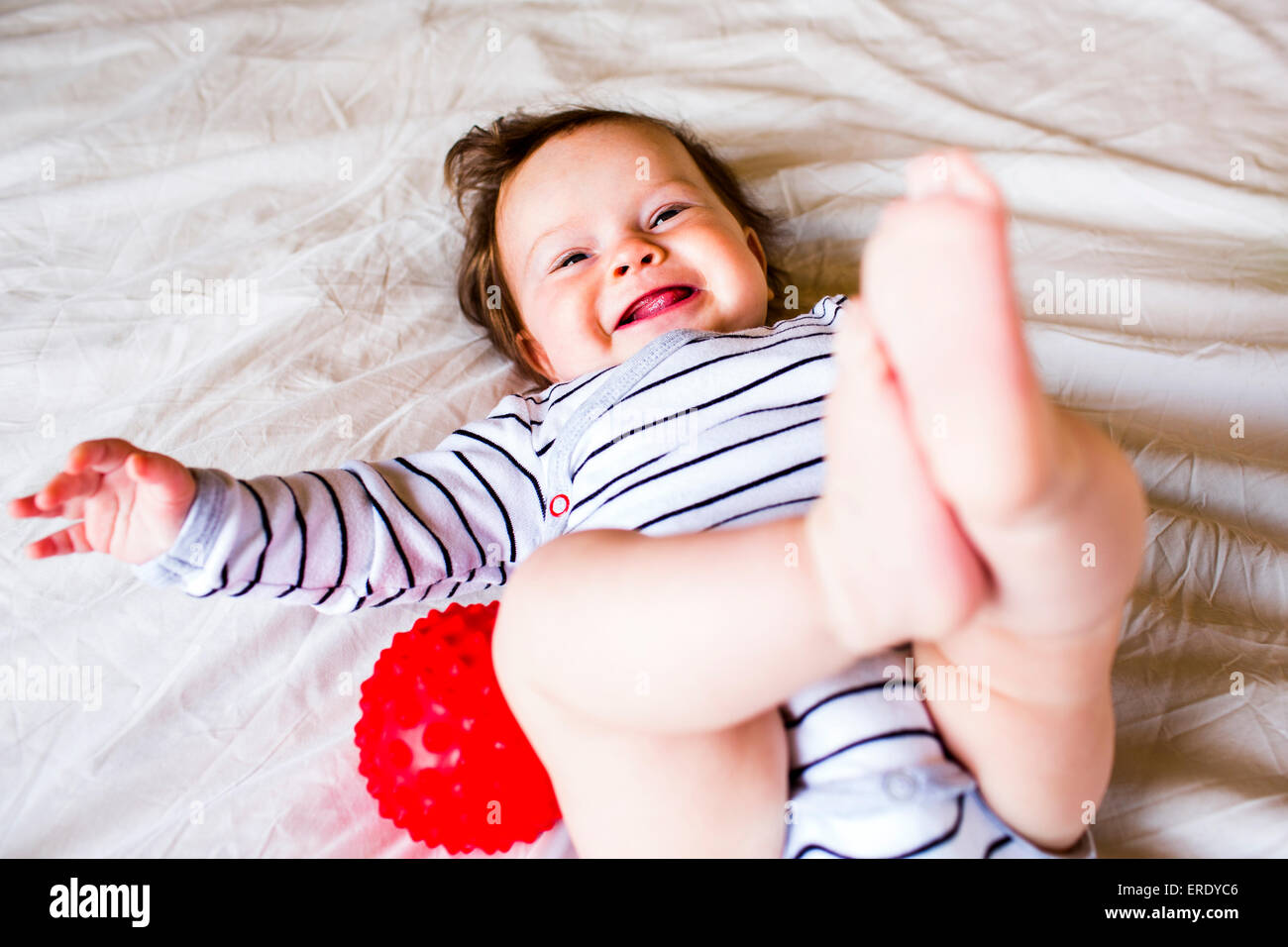 Caucasian Baby girl ridere sul letto Foto Stock