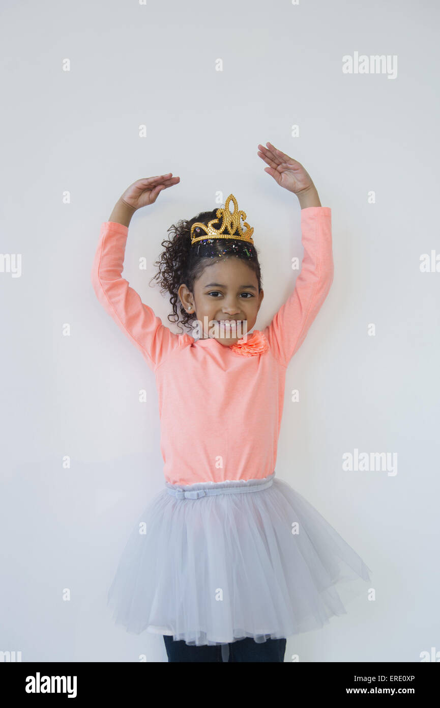 Sorridente razza mista ballerina in posa di tiara Foto Stock