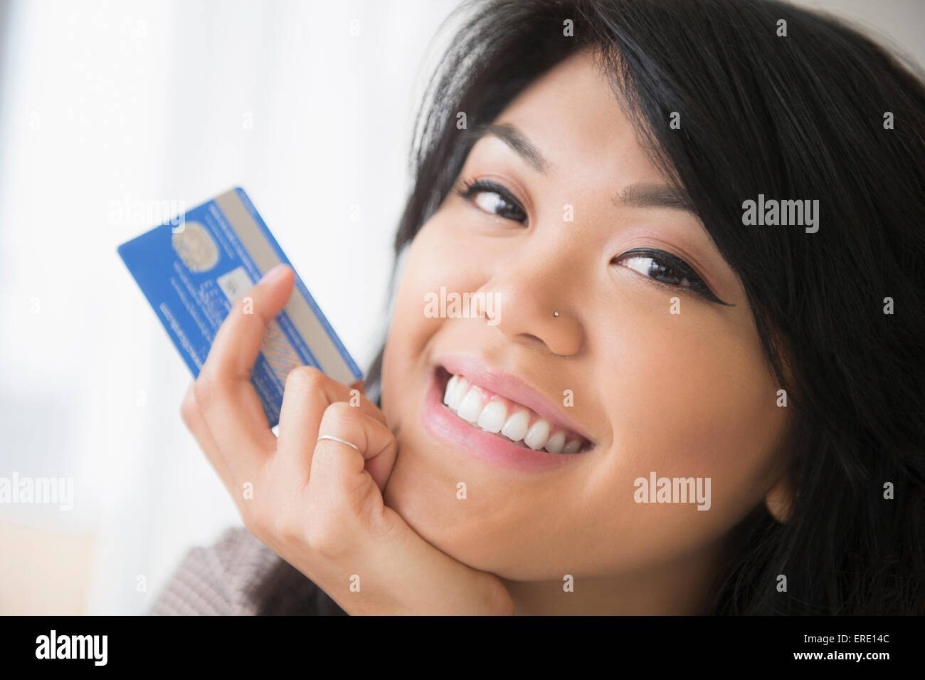 Sorridente Pacific Islander donna azienda carta di credito Foto Stock