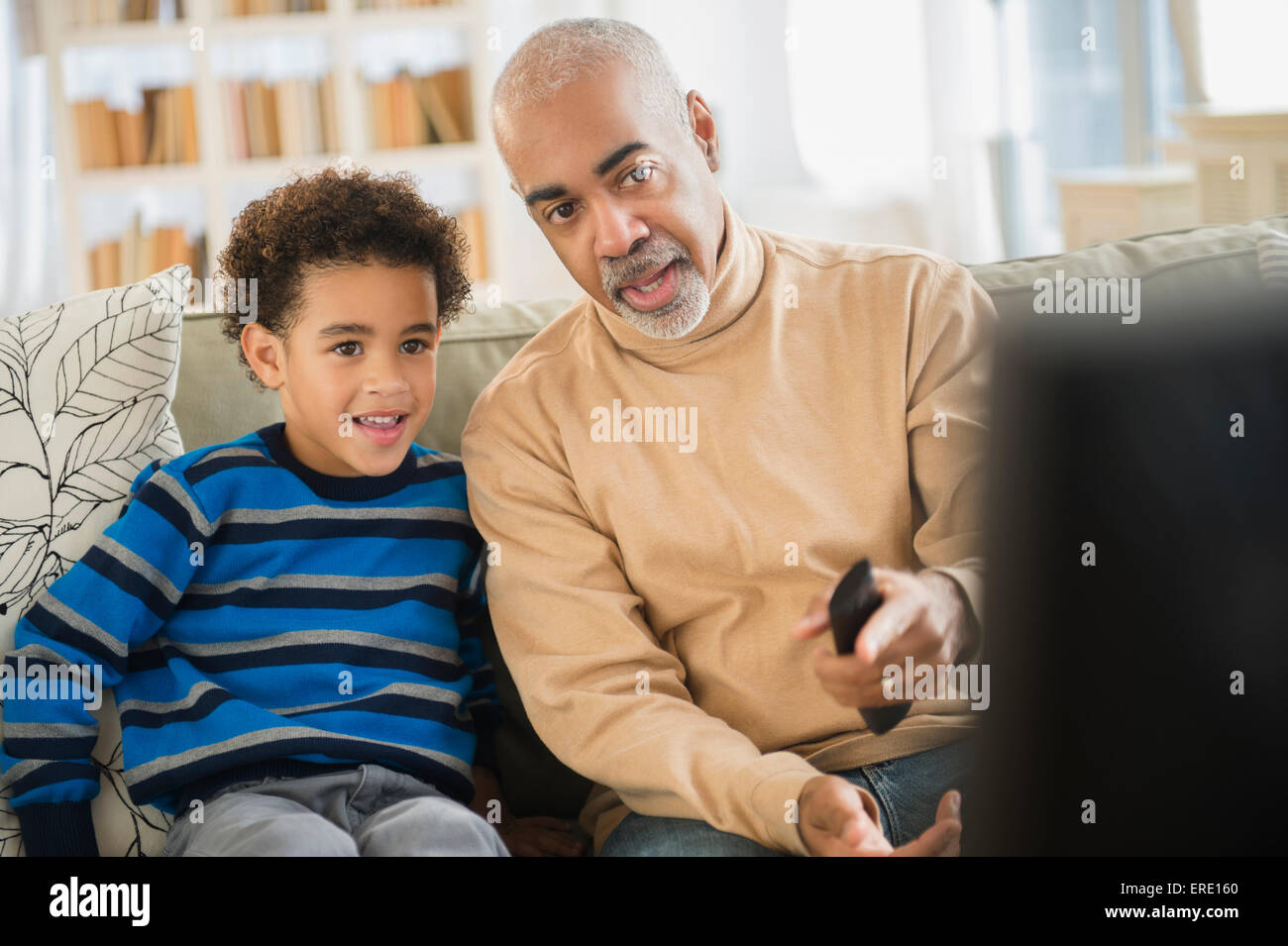 Razza mista nonno e nipote di guardare la televisione Foto Stock
