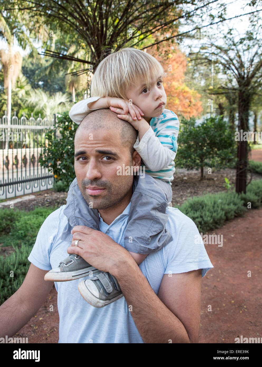 Ispanico padre figlio che porta sulle spalle in posizione di parcheggio Foto Stock