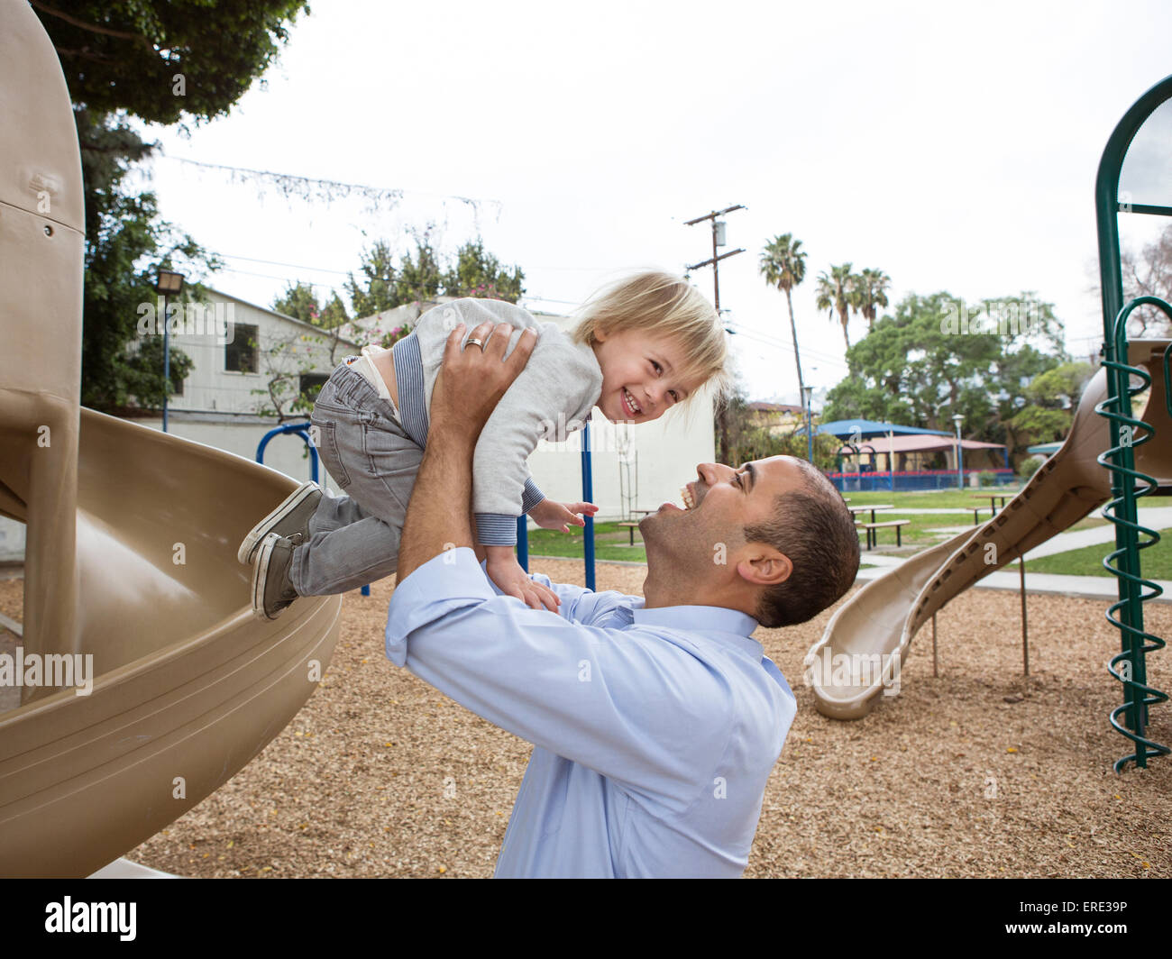 Ispanico padre e figlio giocando sul parco giochi Foto Stock