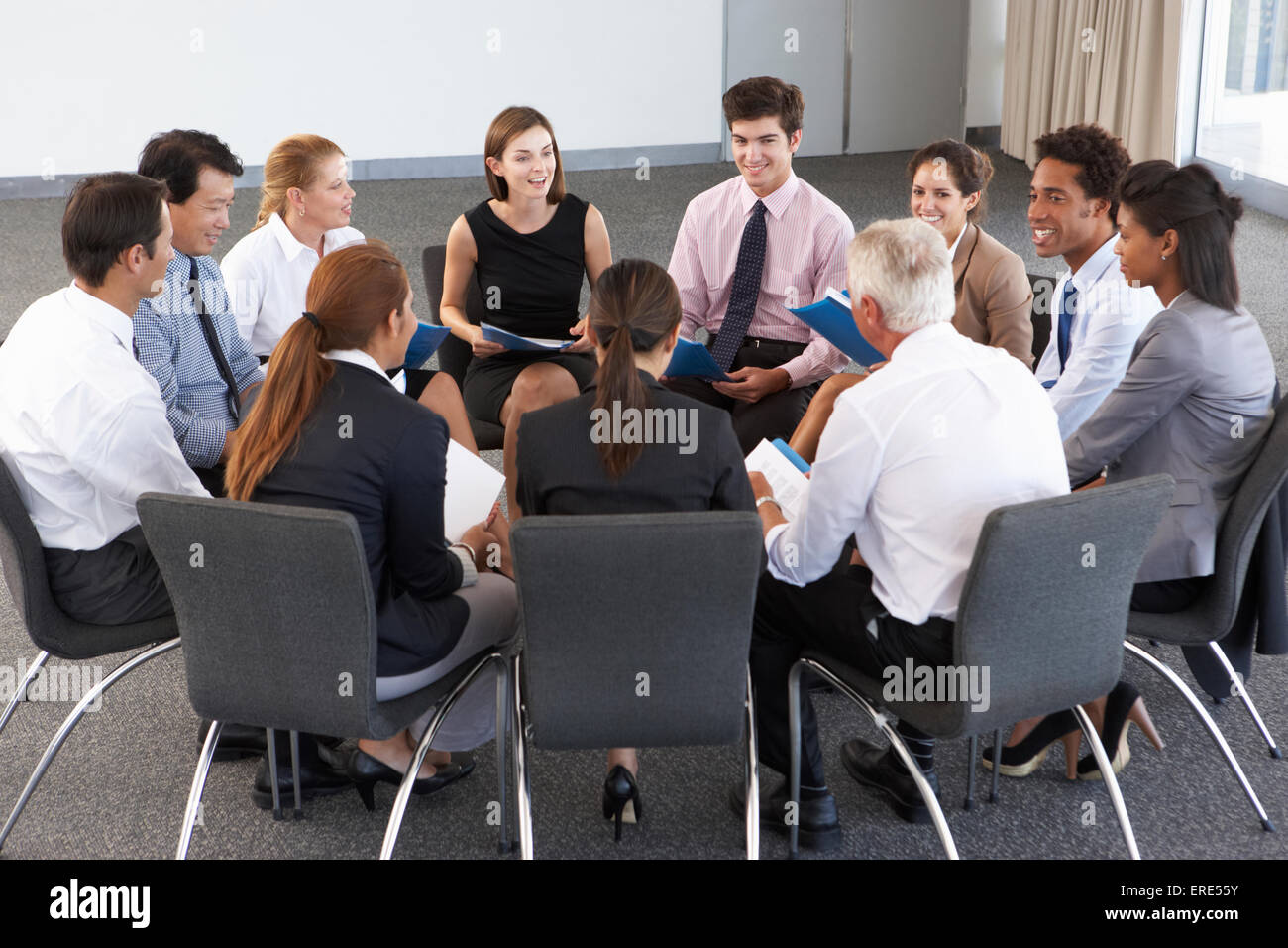 Gli imprenditori seduti in cerchio in seminario della società Foto Stock