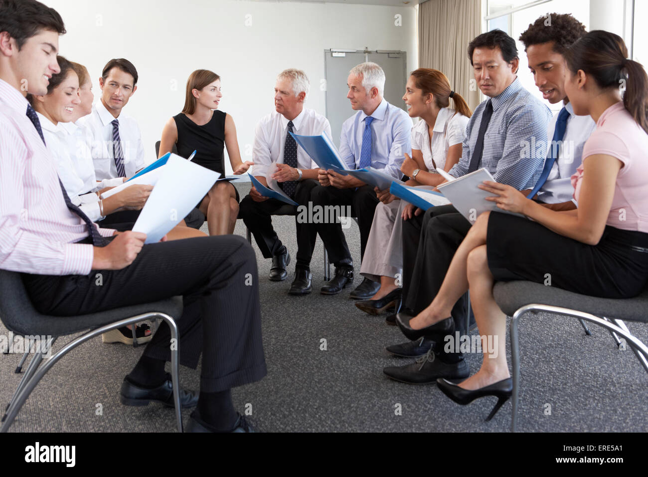 Gli imprenditori seduti in cerchio in seminario della società Foto Stock