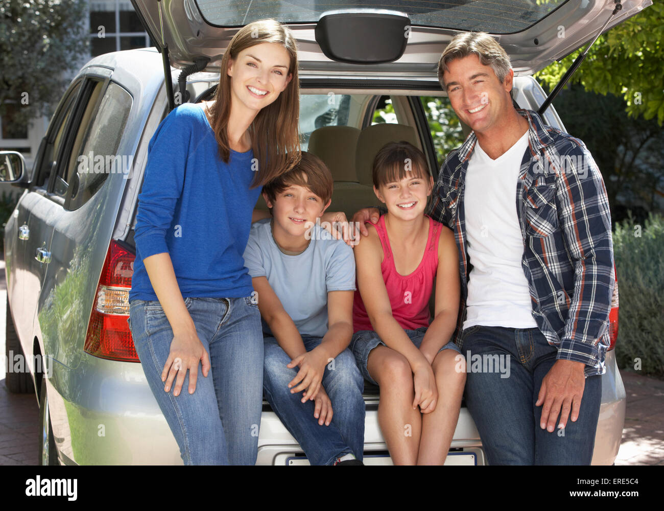Famiglia seduta nel portabagagli della vettura Foto Stock