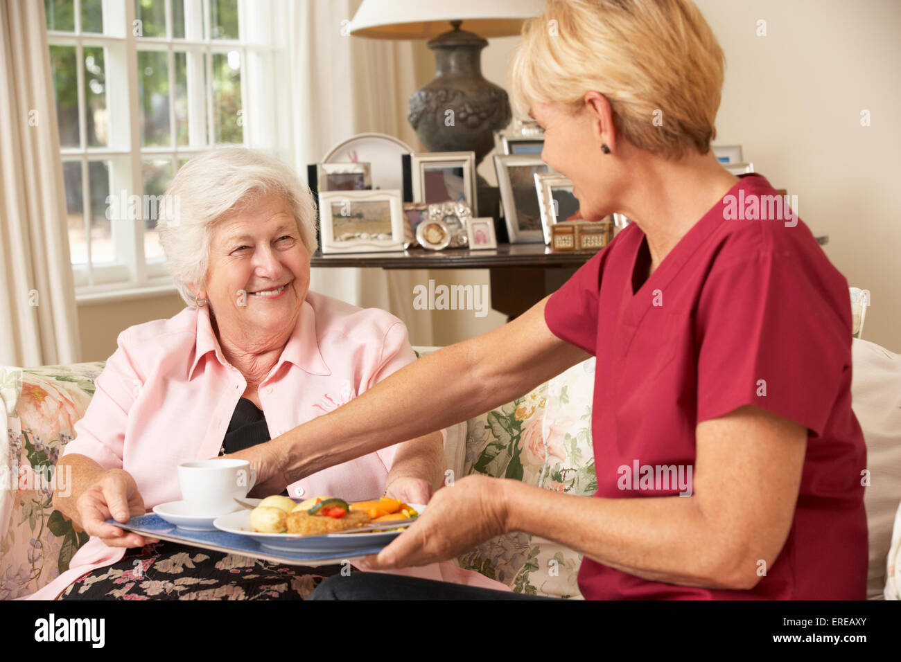 Servizio Helper Senior donna con pasto in casa di cura Foto Stock