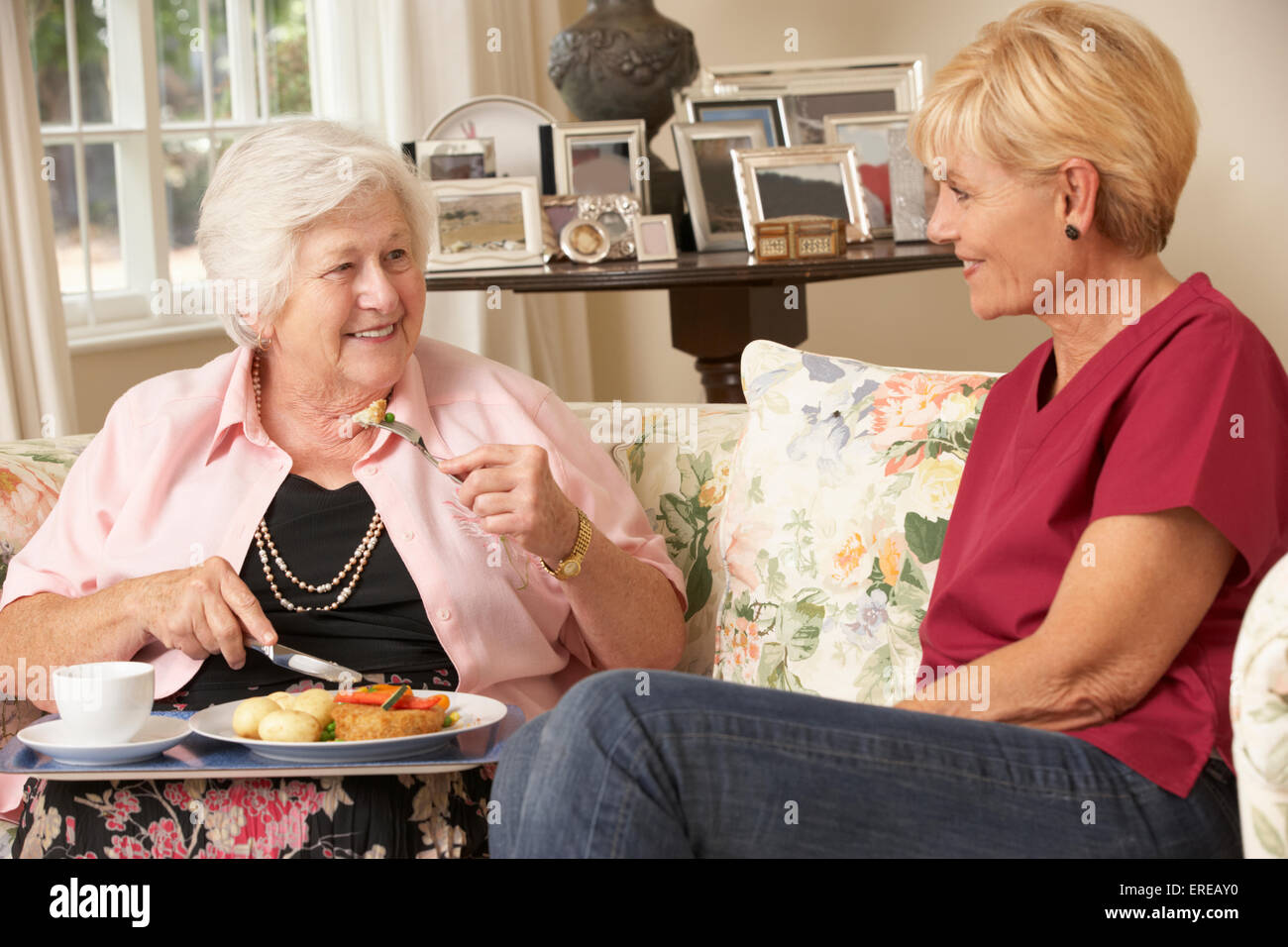 Servizio Helper Senior donna con pasto in casa di cura Foto Stock