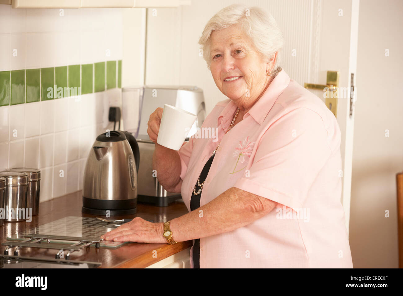 Senior pensionati donna in cucina rendendo bevanda calda Foto Stock