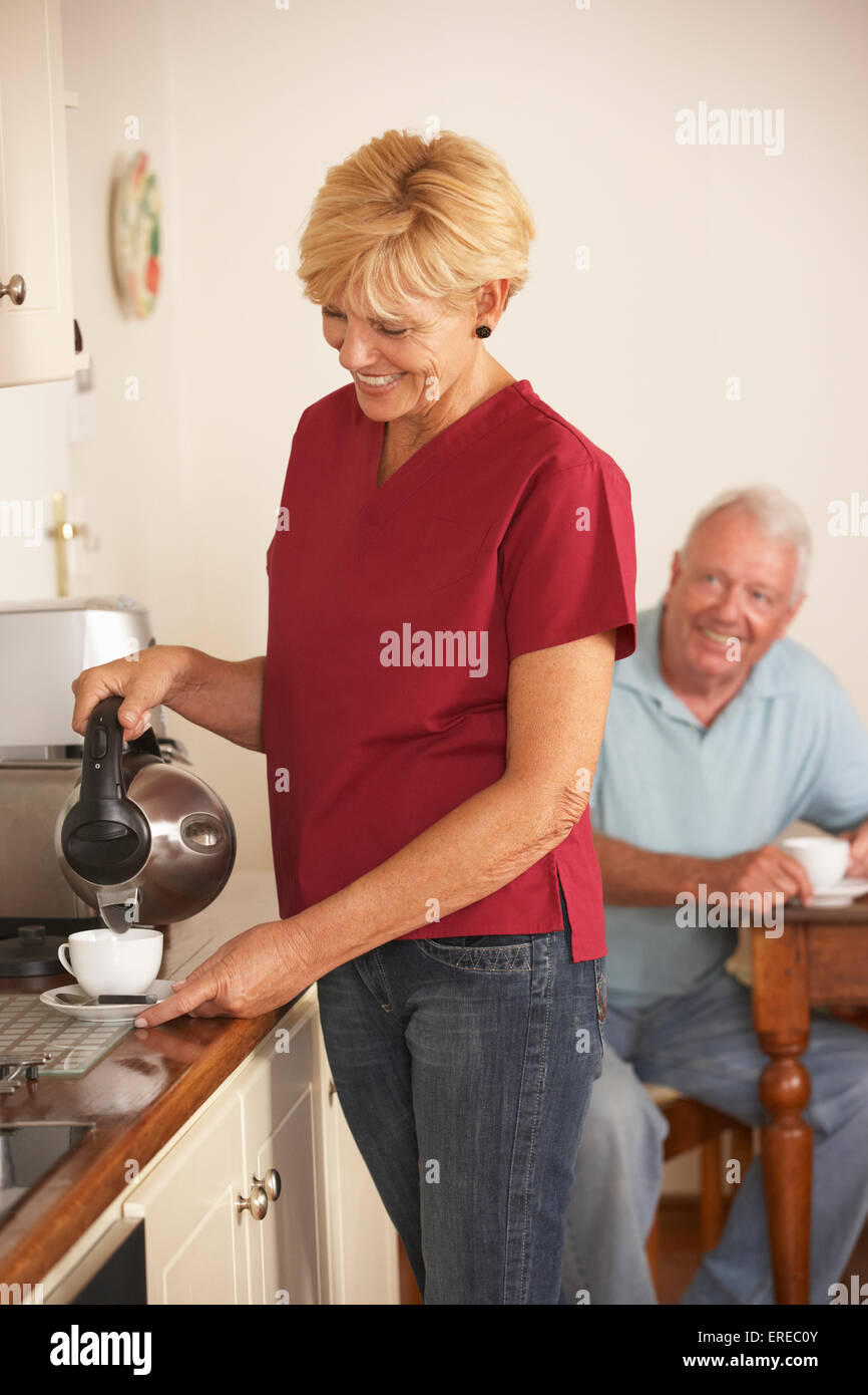 Home Help Condividere tazza di tè con i Senior maschi in cucina Foto Stock