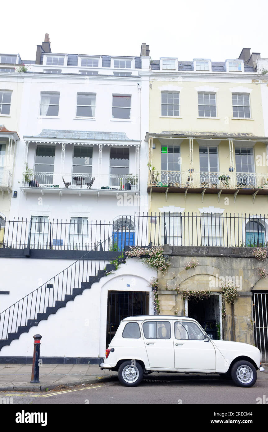 Un bianco auto parcheggiate sulla strada di Bristol sotto il grado II* elencati terrazza di 46 case sul Royal York Crescent. Foto Stock