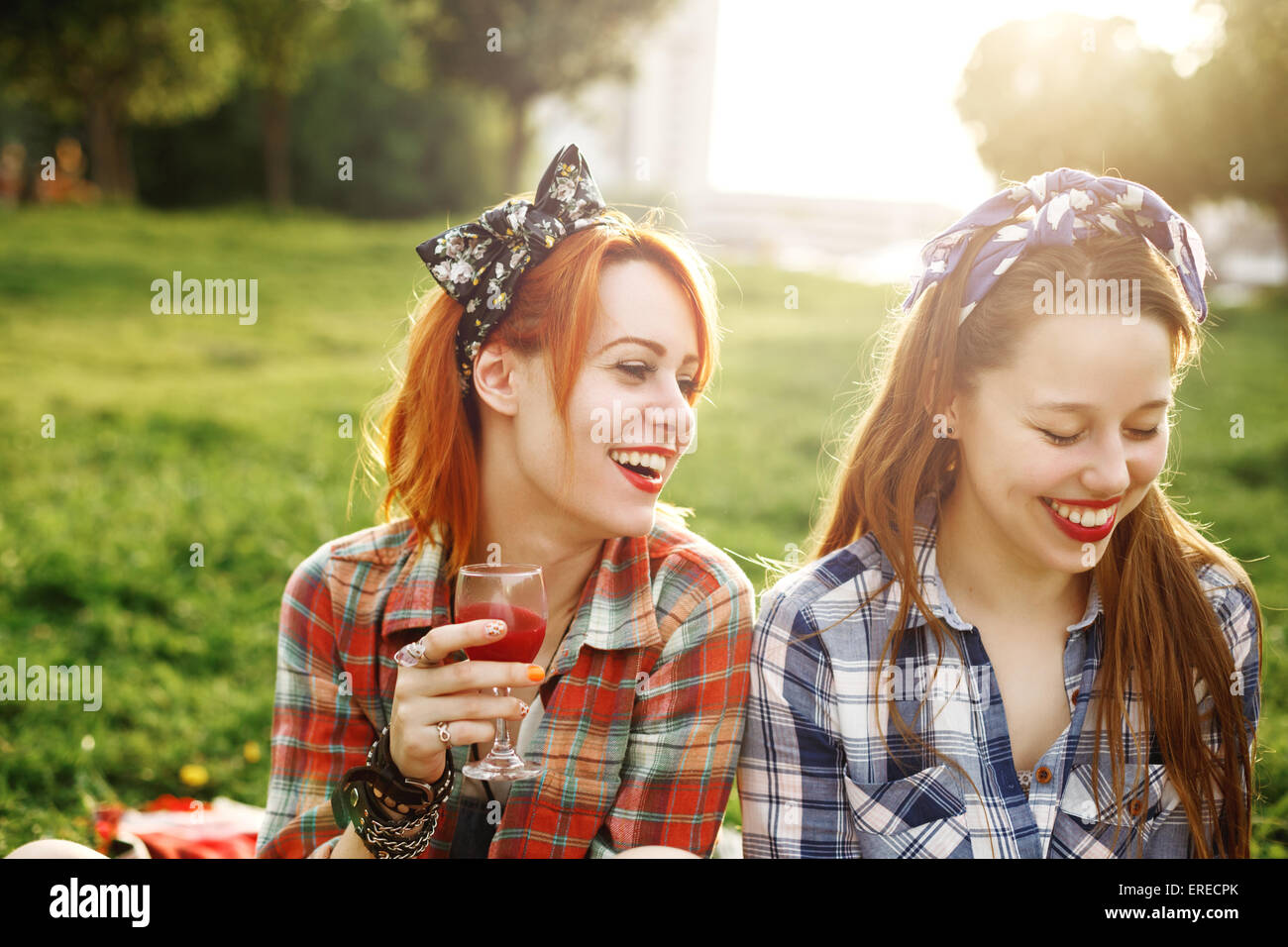 Due giovani ragazze felici in stile Pin-Up su pic-nic, ridere, bere vino,  divertendosi. Messa a fuoco selettiva Foto stock - Alamy