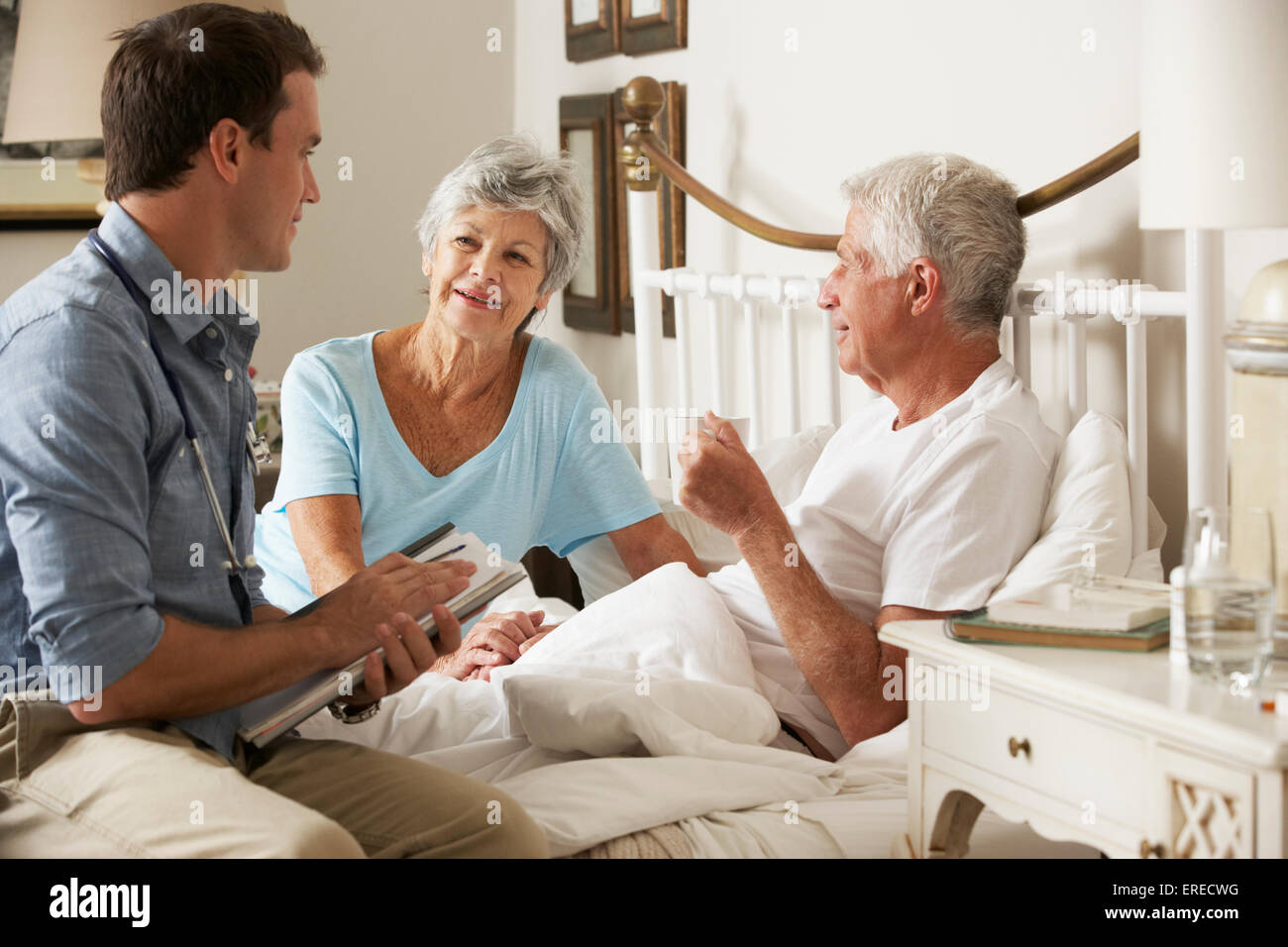 Medico su Home Visita a discutere di salute di Senior paziente di sesso maschile con mia moglie Foto Stock