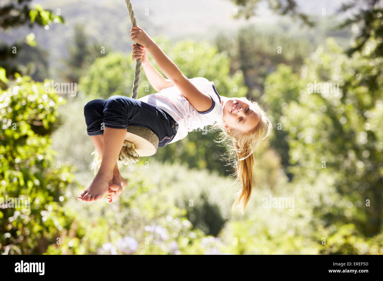 Giovane ragazza Divertirsi su swing corda Foto Stock