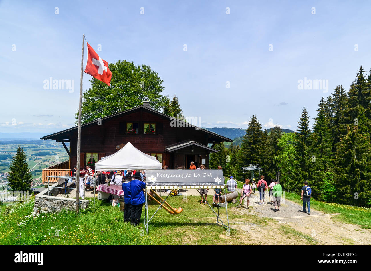 Musicisti tradizionali giocando cor des Alpes (alphorn) in Svizzera da un café con turisti Foto Stock