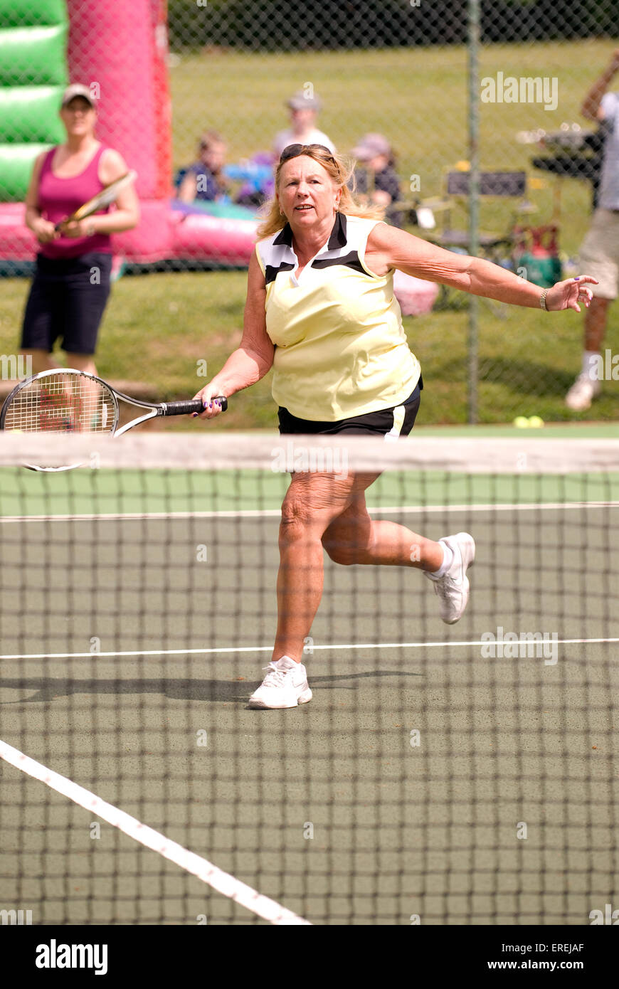 Donna anziana prendendo parte a una Carità evento tennis, Headley, Hampshire, Regno Unito. Foto Stock