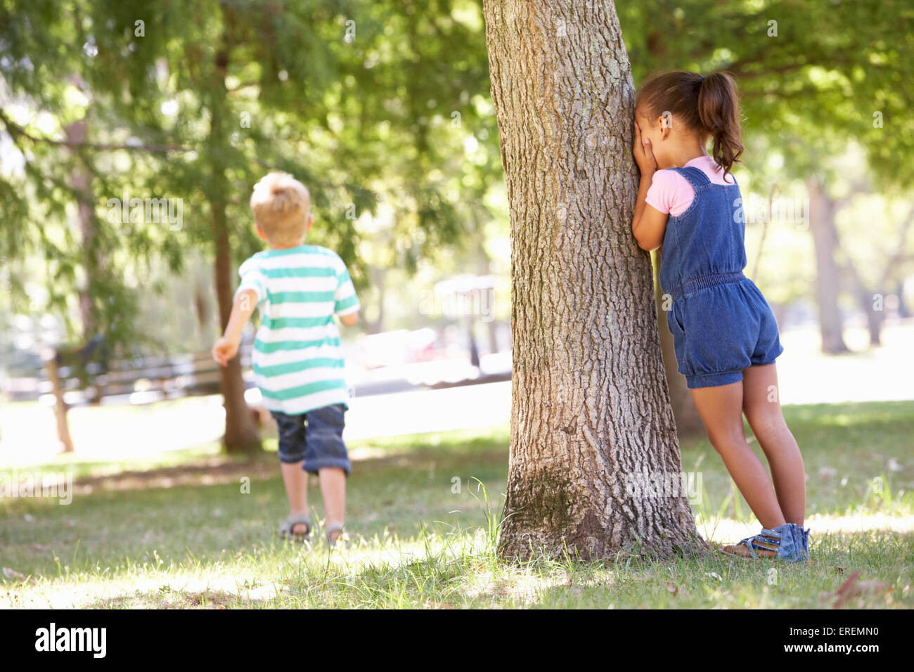 Due bambini che giocano a nascondino nel Parco Foto Stock