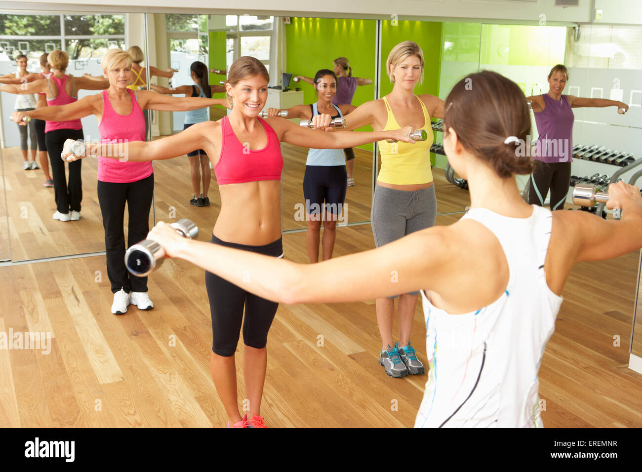 Le donne che prendono parte nella palestra Fitness classe usando i pesi Foto Stock