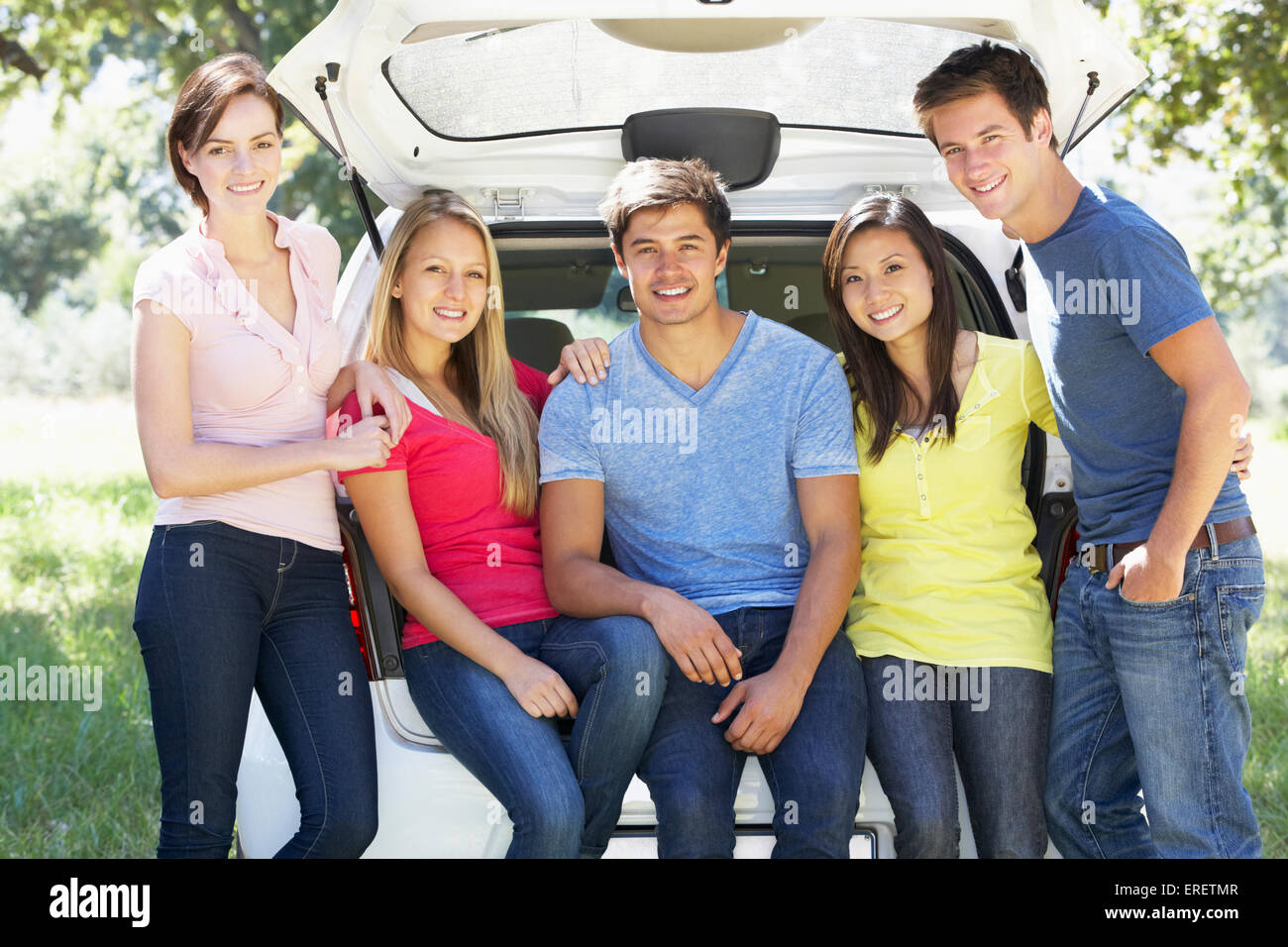 Un gruppo di giovani amici seduti nel portabagagli della vettura Foto Stock