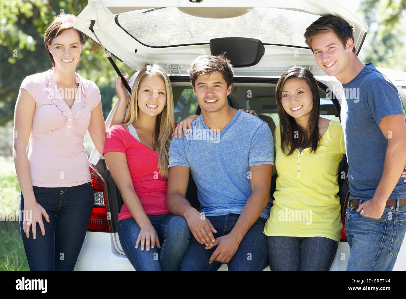 Un gruppo di giovani amici seduti nel portabagagli della vettura Foto Stock