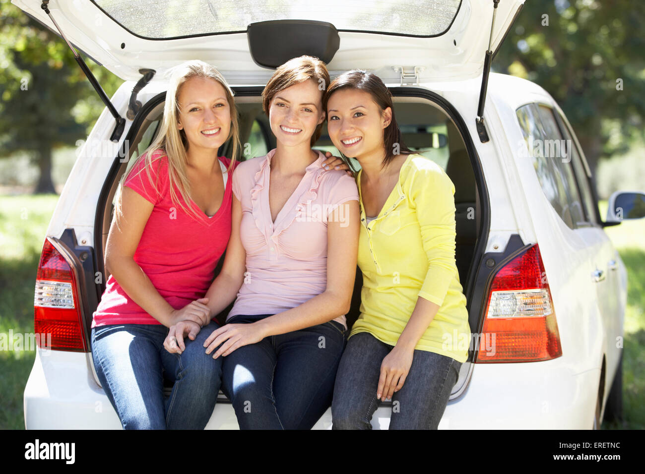 Tre giovani donne seduta nel portabagagli della vettura Foto Stock