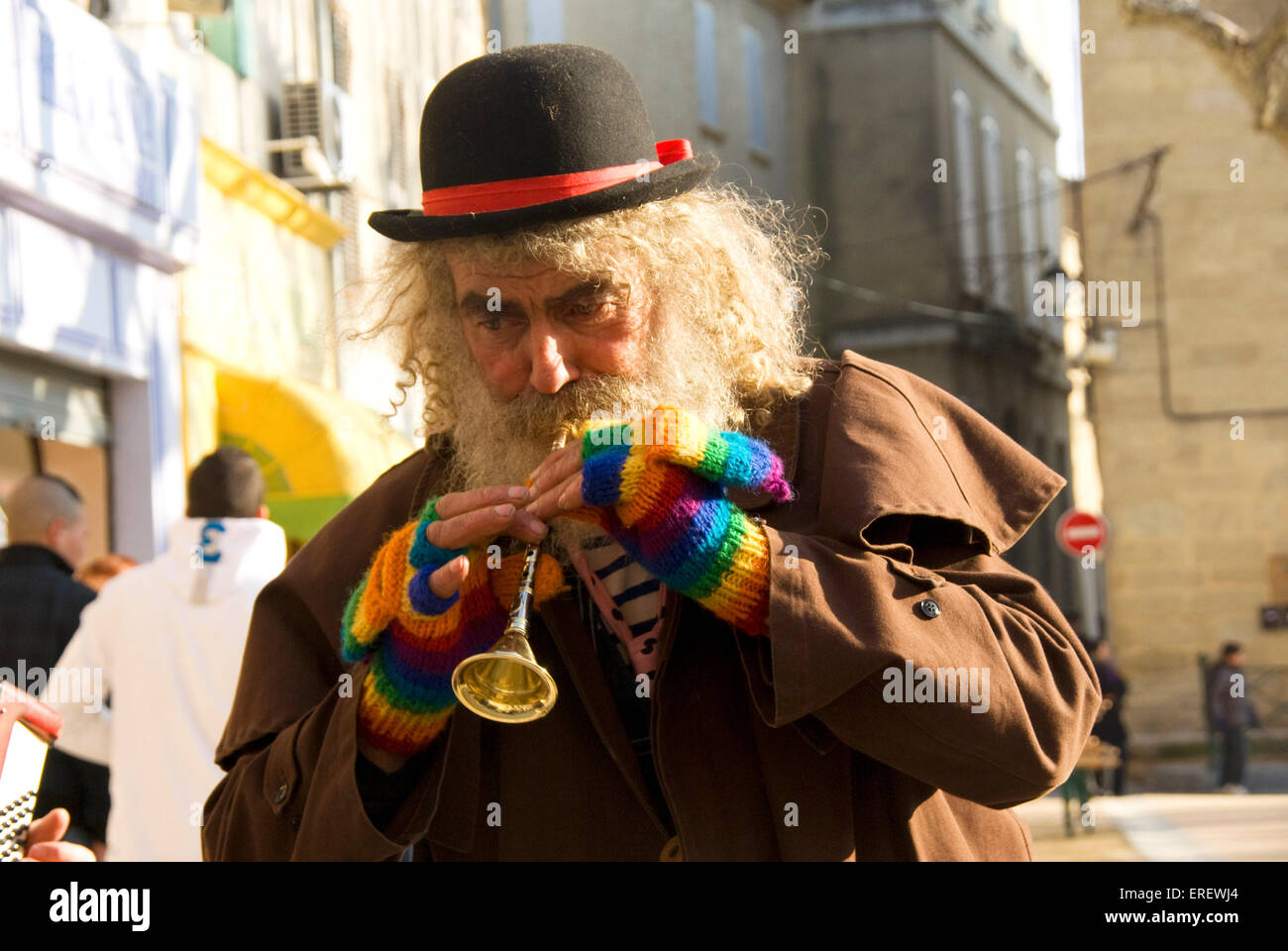 Hirsute, bianco con capelli uomo con bombetta colorato e muffole giocando  un giocattolo tromba nel villaggio di Roquemaure, meridionale Foto stock -  Alamy