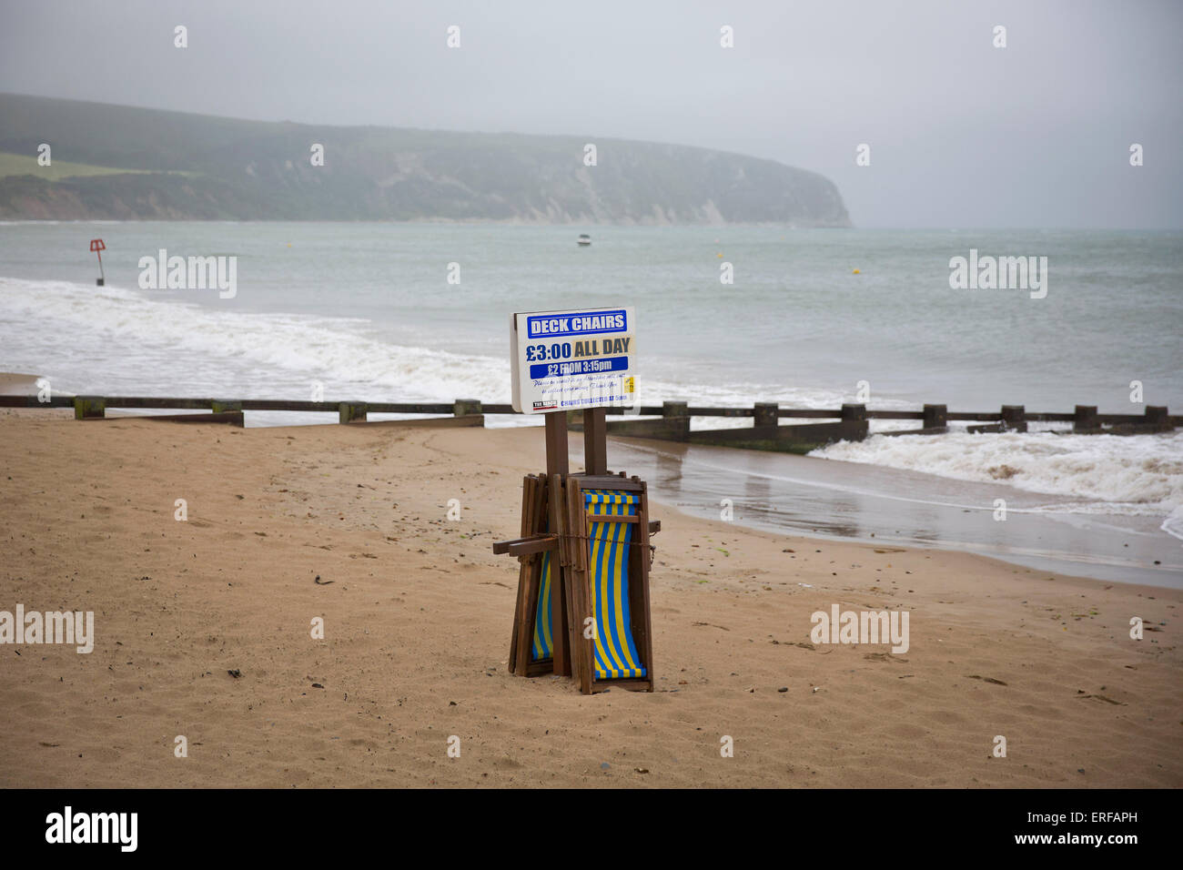 Regno Unito, Swanage : le sedie a sdraio sono visto disperse su una spiaggia vuota sotto la pioggia a Swanage, Dorset, il 1 giugno 2015. Foto Stock