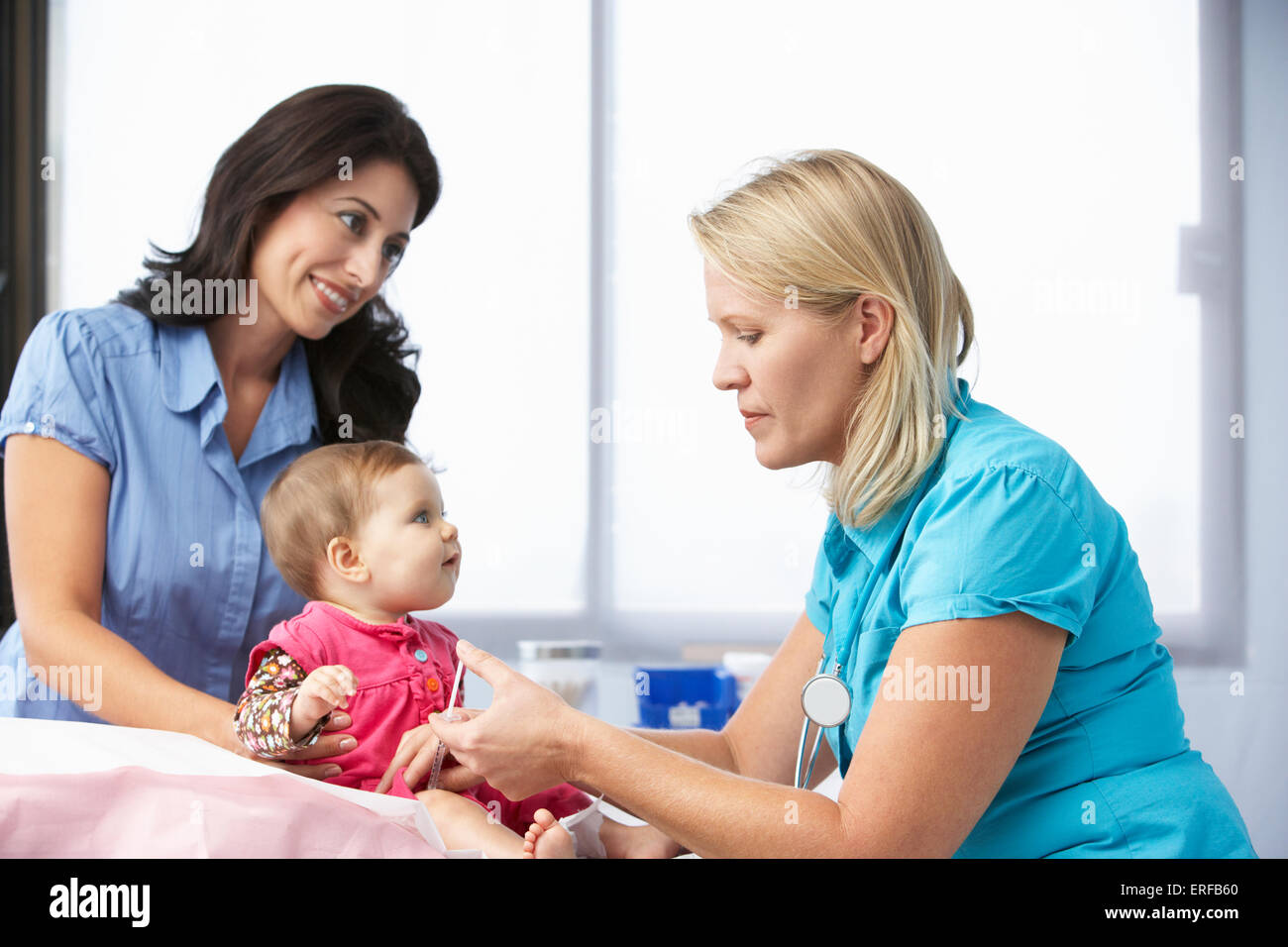 Dottore in chirurgia dando Baby girl iniezione Foto Stock